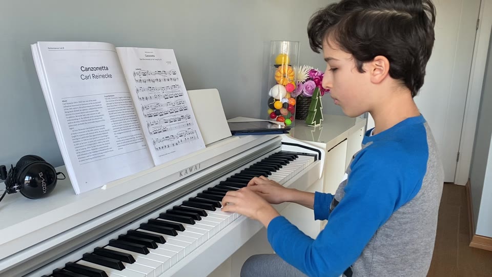 Beyaz piyano başında Canzonetta çalan öğrenci